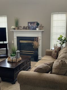 a living room filled with furniture and a flat screen tv mounted on a wall above a fire place