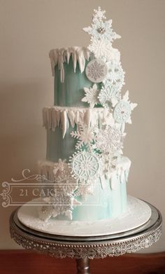 a three tiered cake decorated with snowflakes and icing