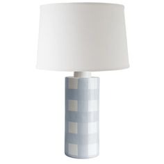 a white and blue table lamp with a white shade on the top, in front of a white background