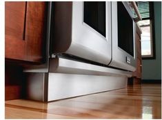 a close up view of the bottom part of a stainless steel oven with wood flooring