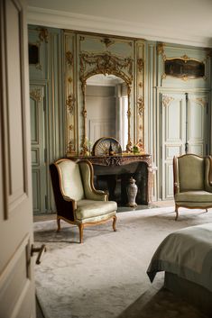 a bedroom with two chairs and a fireplace