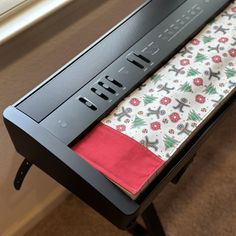 an open laptop computer sitting on top of a wooden desk next to a red and white napkin