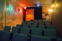 an empty theater with blue chairs and lights