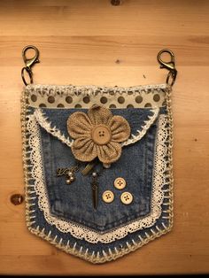 an old pair of jeans hanging on a wall with buttons and lace around the pocket