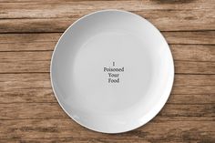 a white plate with the words i poised your food on it sitting on a wooden table