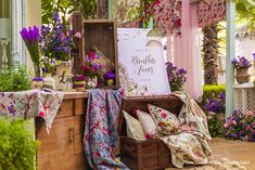 a display in a flower shop filled with lots of colorful flowers and plants on top of wooden boxes