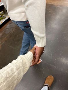 two people holding hands while standing next to each other