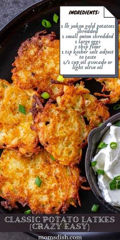 potato cakes with sour cream and green onions on a black plate next to a small bowl of sour cream