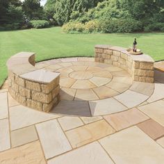 an outdoor patio with stone seating area and green grass in the backgroung