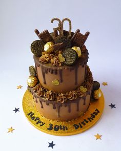 a birthday cake with chocolate frosting and gold decorations