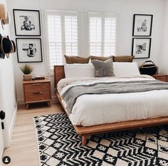 a bed sitting in a bedroom next to a window with shutters on the windowsill