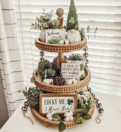 a three tiered tray with plants and signs on it that read lucky me, i love you