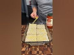 a person cutting up some food in a pan