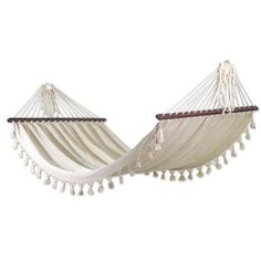 two white hammocks with tassels hanging from the sides, one is empty