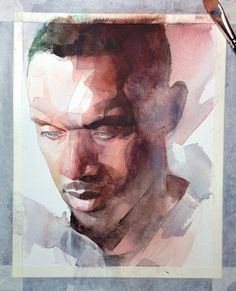 a watercolor painting of a man's face on a piece of paper