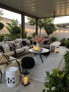 an outdoor living area with couches, tables and candles