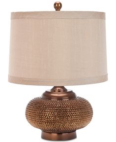 a table lamp with a beige shade on it and a gold finish around the base