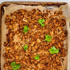 a casserole dish filled with meat and garnished with cilantro