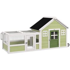 a green and white chicken coop with a black roof