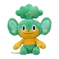 a green and yellow stuffed animal with big ears on it's head, sitting in front of a white background