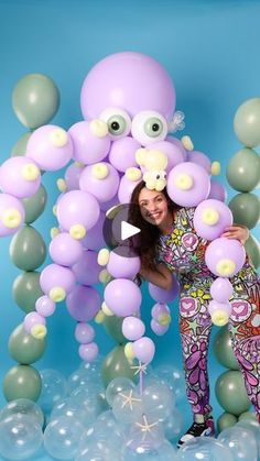 a woman standing in front of balloons with an octopus on it's head and eyes