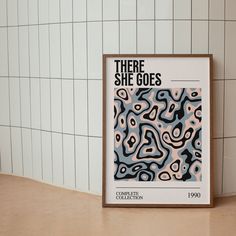 there she goes poster on the wall next to a tiled wall with white and black tiles