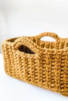 a crocheted basket sitting on top of a white table