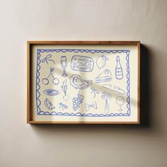 a blue and white drawing on a wall next to a wooden frame with wine glasses