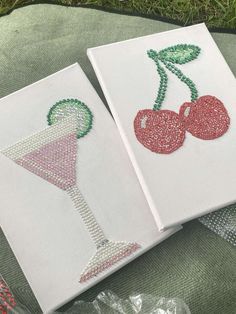 two embroidered cocktail glasses with cherries on them