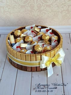 a basket filled with lots of chocolates on top of a wooden floor next to a wall