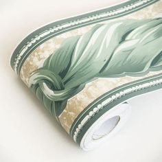 a roll of wallpaper with green leaves on it's side and white background