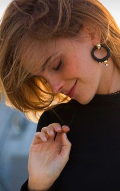 a close up of a person wearing some kind of earring on her left ear