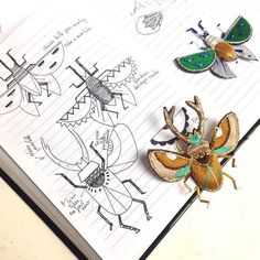 an open book with some drawings and bugs on top of it next to a pencil