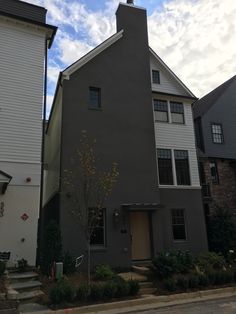 the front of a house with stairs leading up to it's door and windows