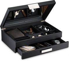 an open black jewelry box filled with lots of different types of items in it's compartments