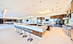 a large kitchen with an island and lots of counter space in the center, along with bar stools