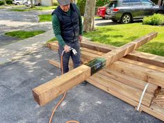 a man sanding down some wood with a power drill and an electric cord attached to it