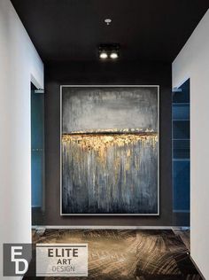 a large painting hanging on the wall in a room with black walls and flooring