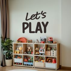 a child's playroom with toys and bookshelves in front of a wall that says let's play