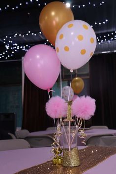 some pink and gold balloons are in a vase