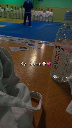 a bottle of water sitting on top of a wooden table