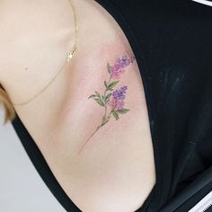 a woman with a tattoo on her shoulder has flowers painted on the back of her arm