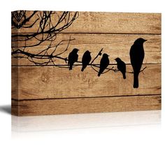 three birds sitting on a branch in front of a wooden wall