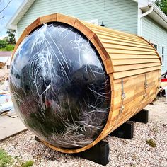 a large wooden barrel sitting in the middle of a yard