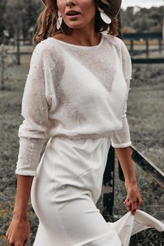 a woman in white is posing for the camera