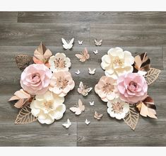 some paper flowers and butterflies on a wooden floor