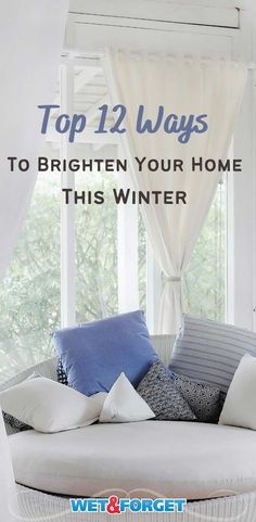 a white couch with blue and white pillows on it in front of a window that says top 12 ways to brighten your home this winter