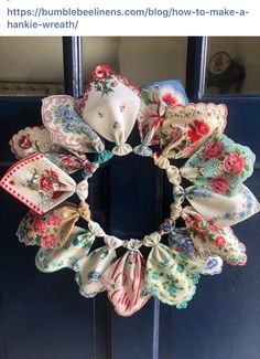 a wreath made out of cloths hanging on the front door with flowers and ribbons around it