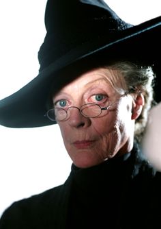 an old woman wearing a black hat and glasses with her eyes wide open in front of the camera