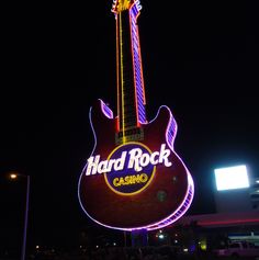 the hard rock casino sign is lit up in purple and red colors with a guitar on top